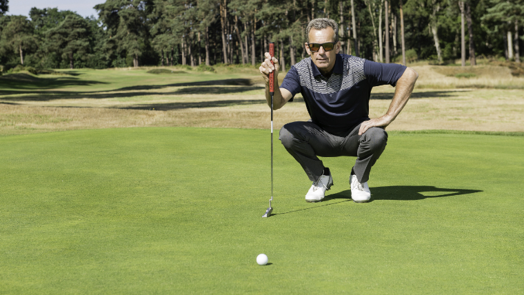 a-golfer-reading-his-putt-on-a-green