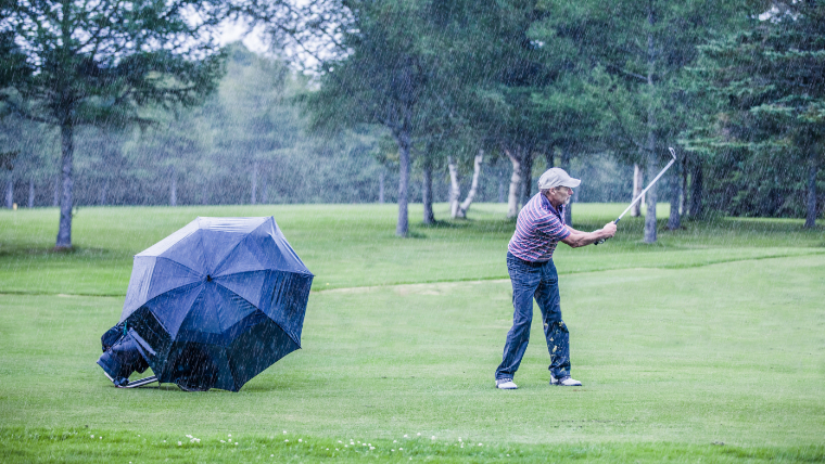 a-man-playing-golf-in-the-rain